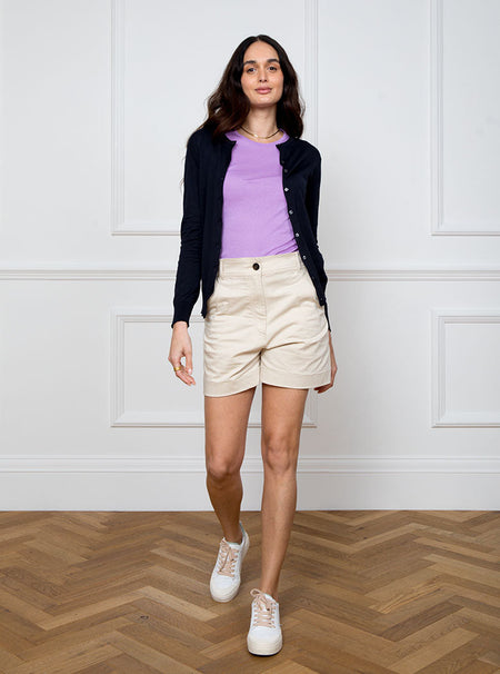 Woman wearing navy blue long sleeve cardigan knit in a luxury and premium sea island cotton. Paired with ultraviolet/lilac short sleeve knit top.